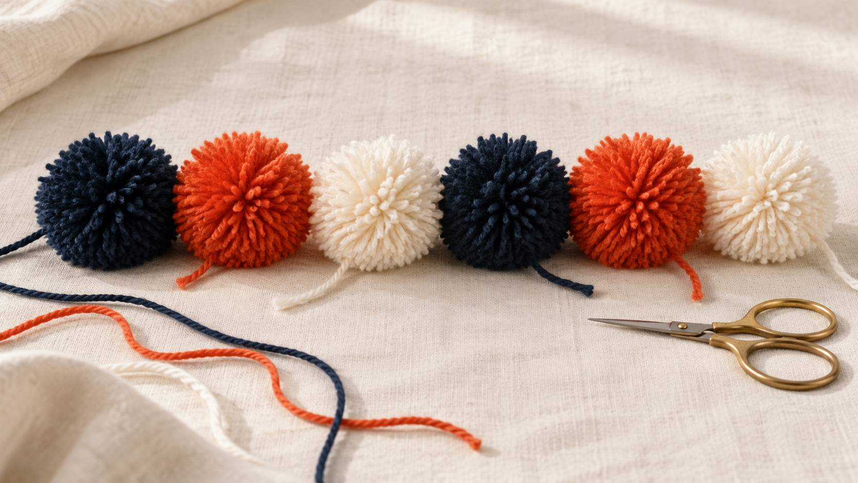 Pompons de laine multicolores alignes sur un tissu neutre